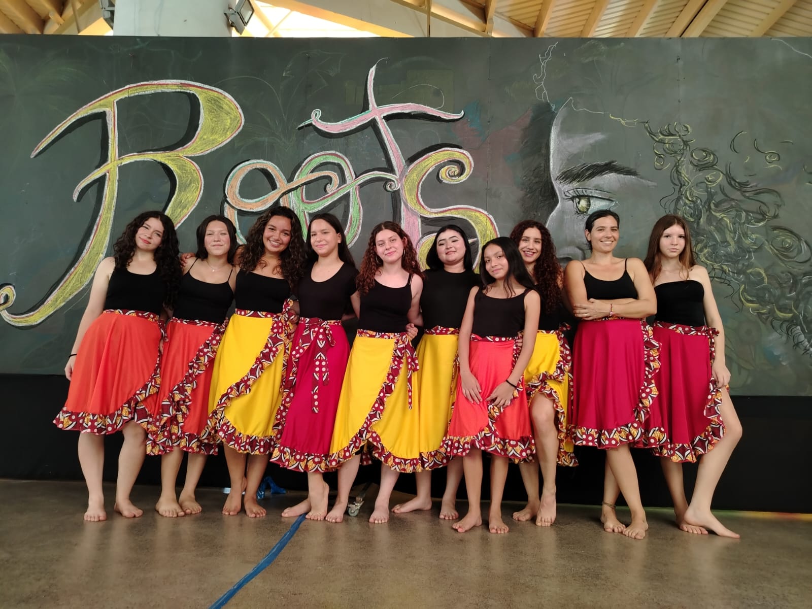 Mujeres jóvenes posando a una foto vestidas con enaguas de colores y blusa negra