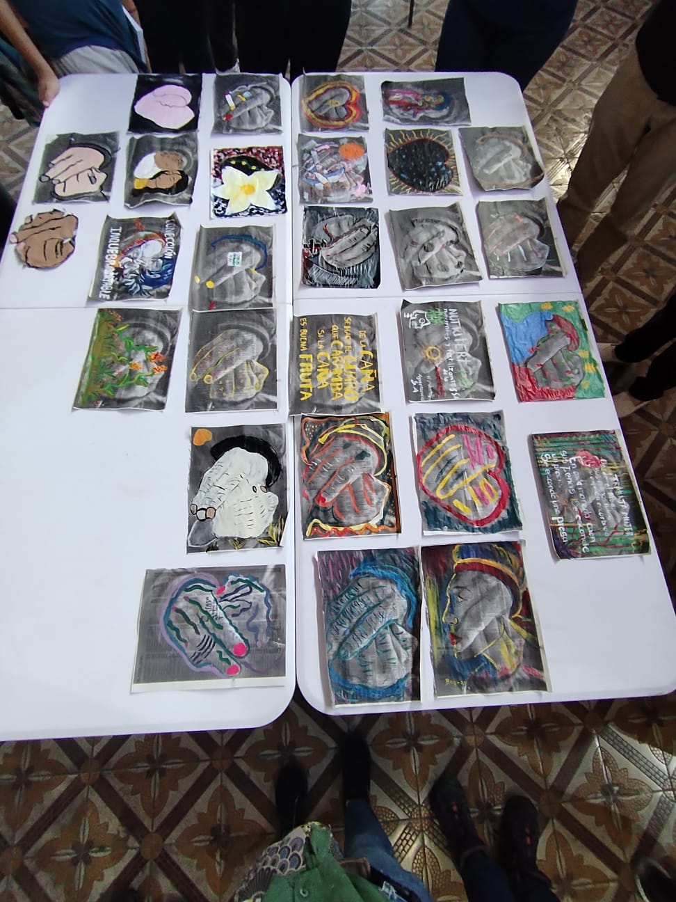 Diferentes obras que representan manos intervenidas de manera artística, puestas sobre una mesa