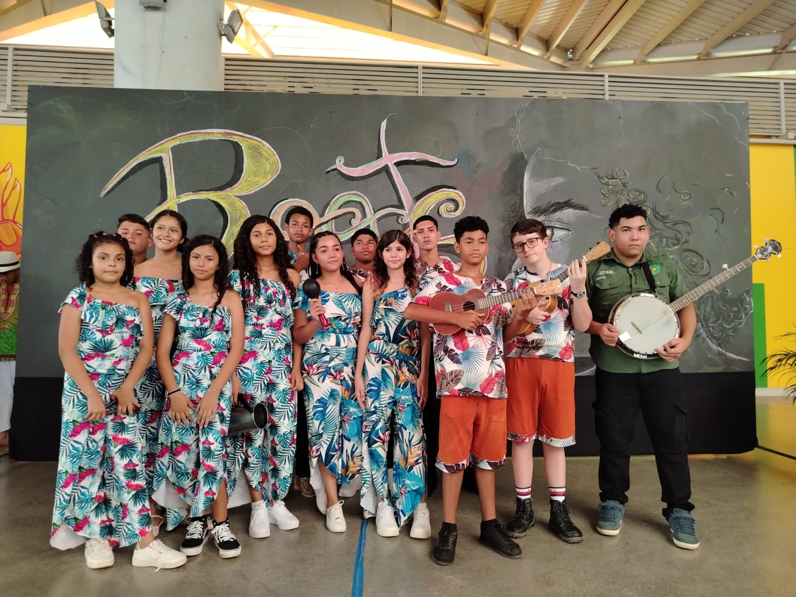 Grupo de jóvenes vestidos con ropa afrocaribeña, y sostienen instrumentos musicales.