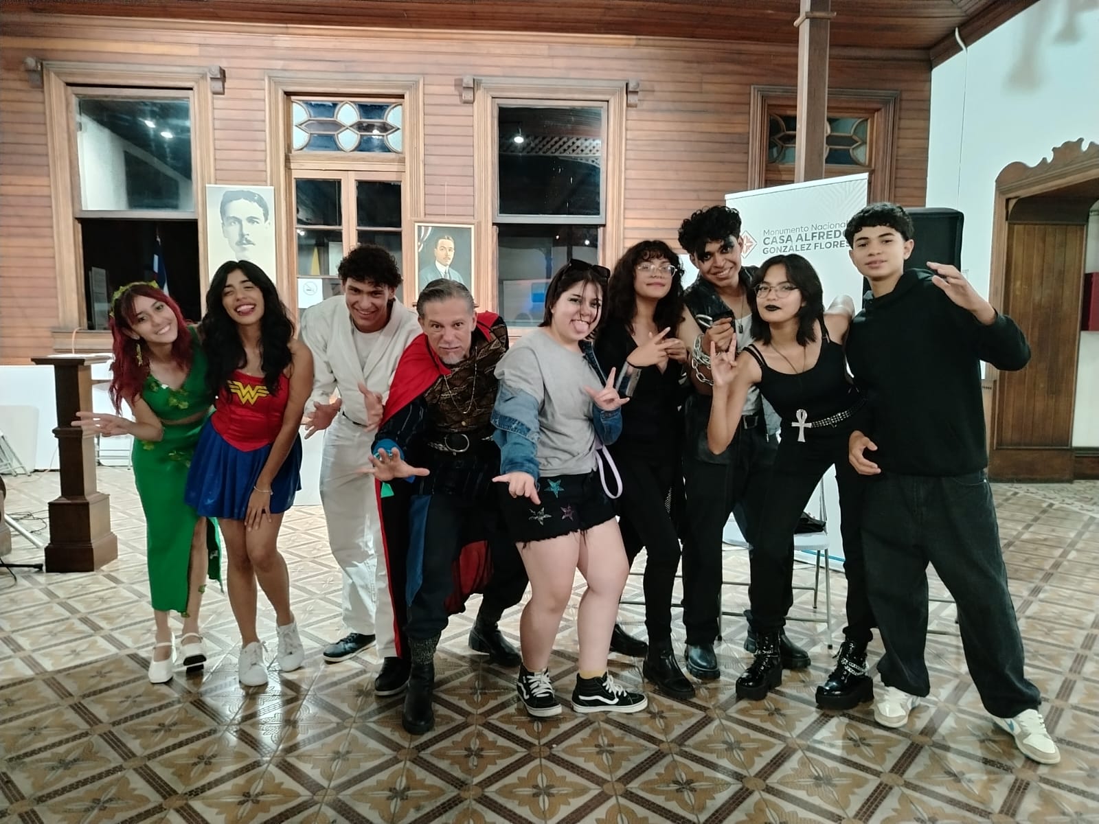 Grupo de jóvenes y un adultos posando con vestuarios de superhéroes.