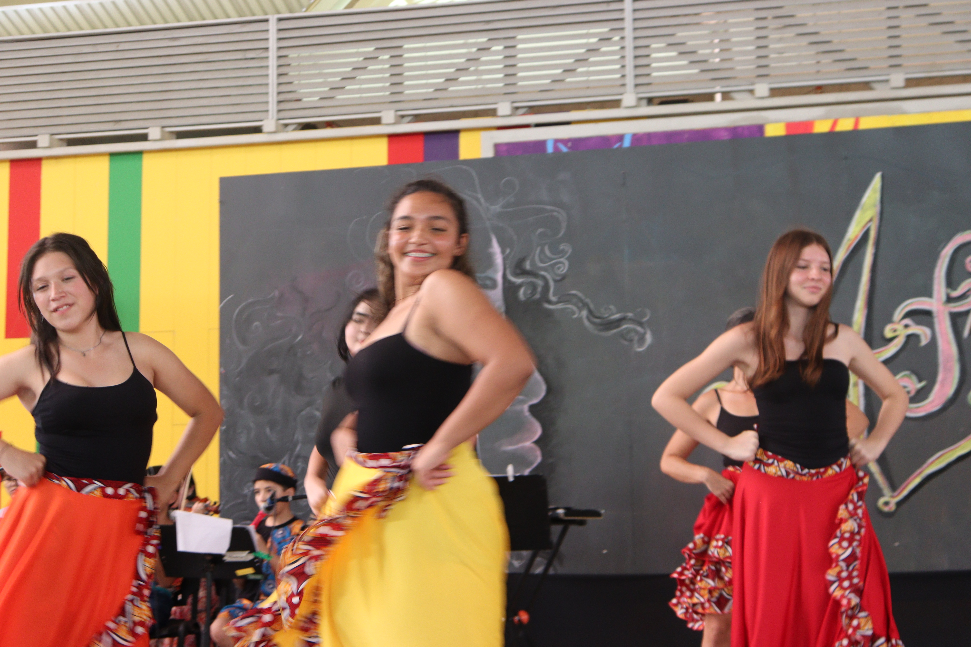 Mujeres jóvenes sonriendo mientras bailan, vestidas con enaguas.