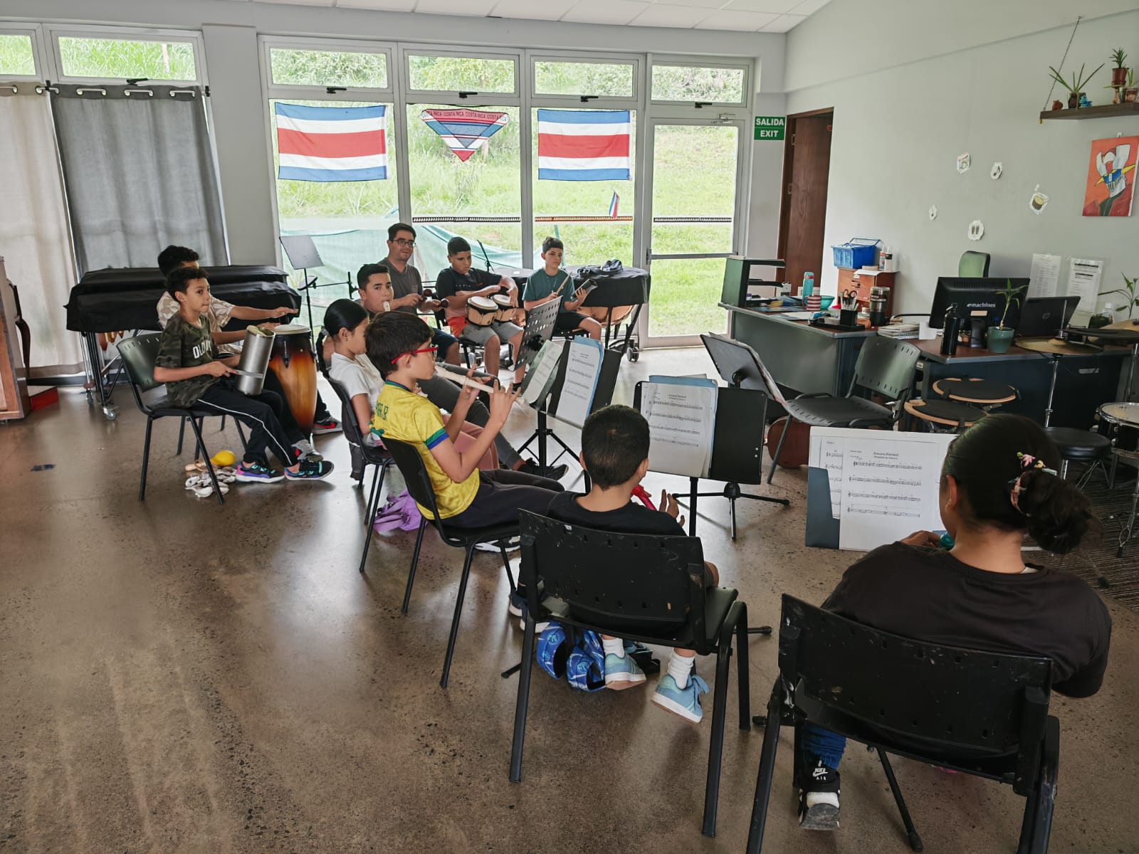 Niños sentados practicando con instrumentos musicales