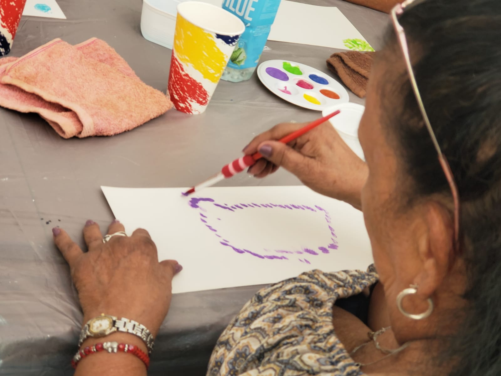 Mujer pintando con pincel sobre una hoja blanca