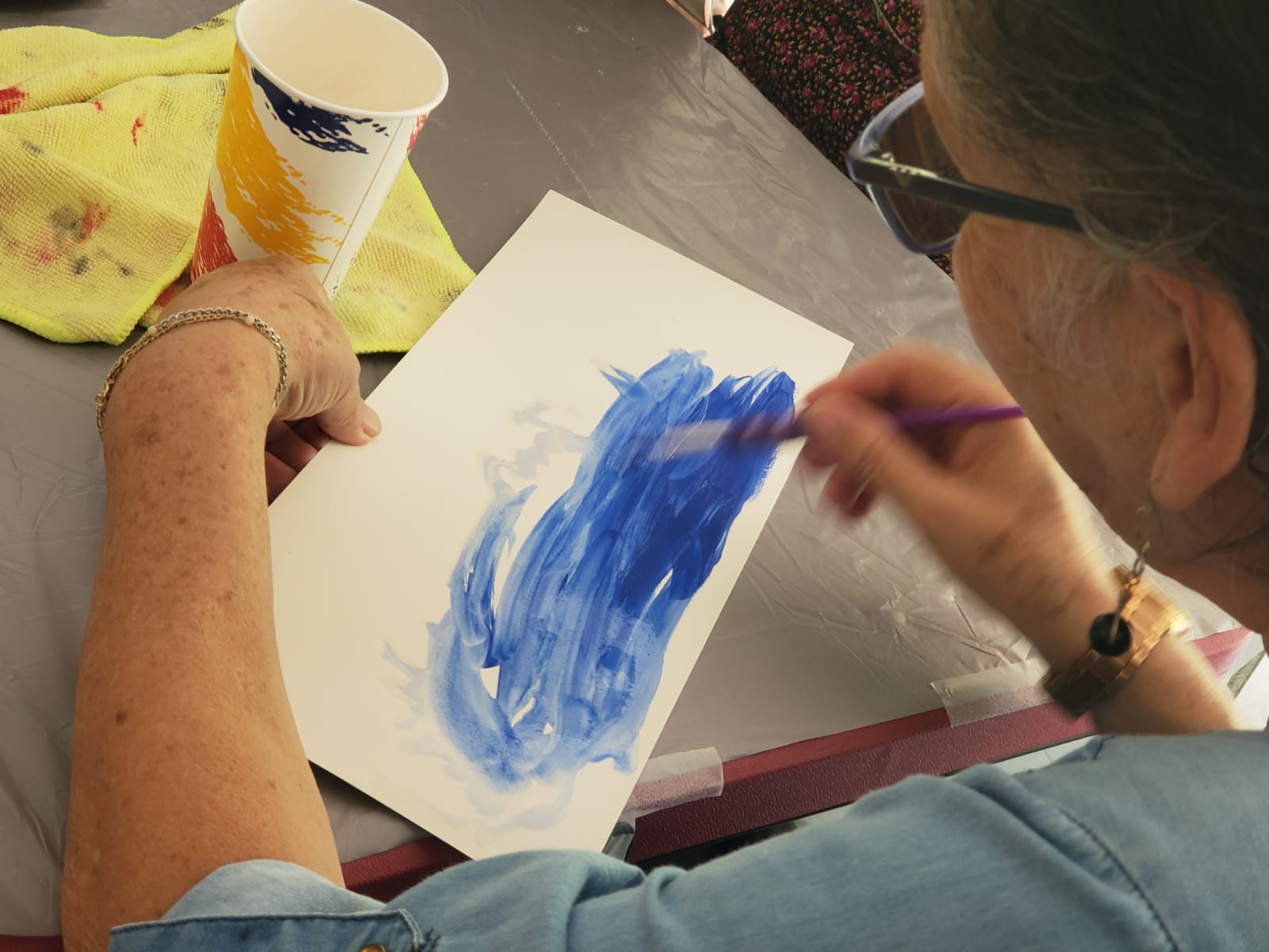 Mujer pintando con pincel sobre una hoja blanca
