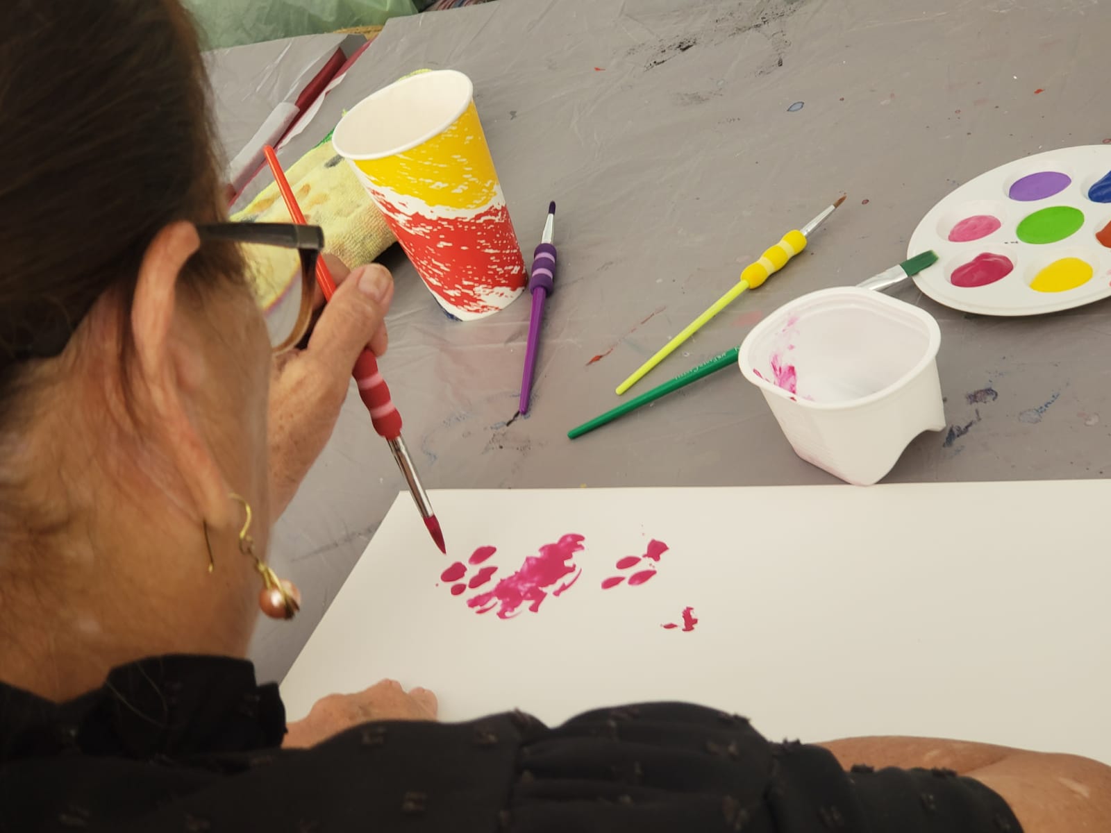 Mujer pintando con pincel sobre una hoja blanca