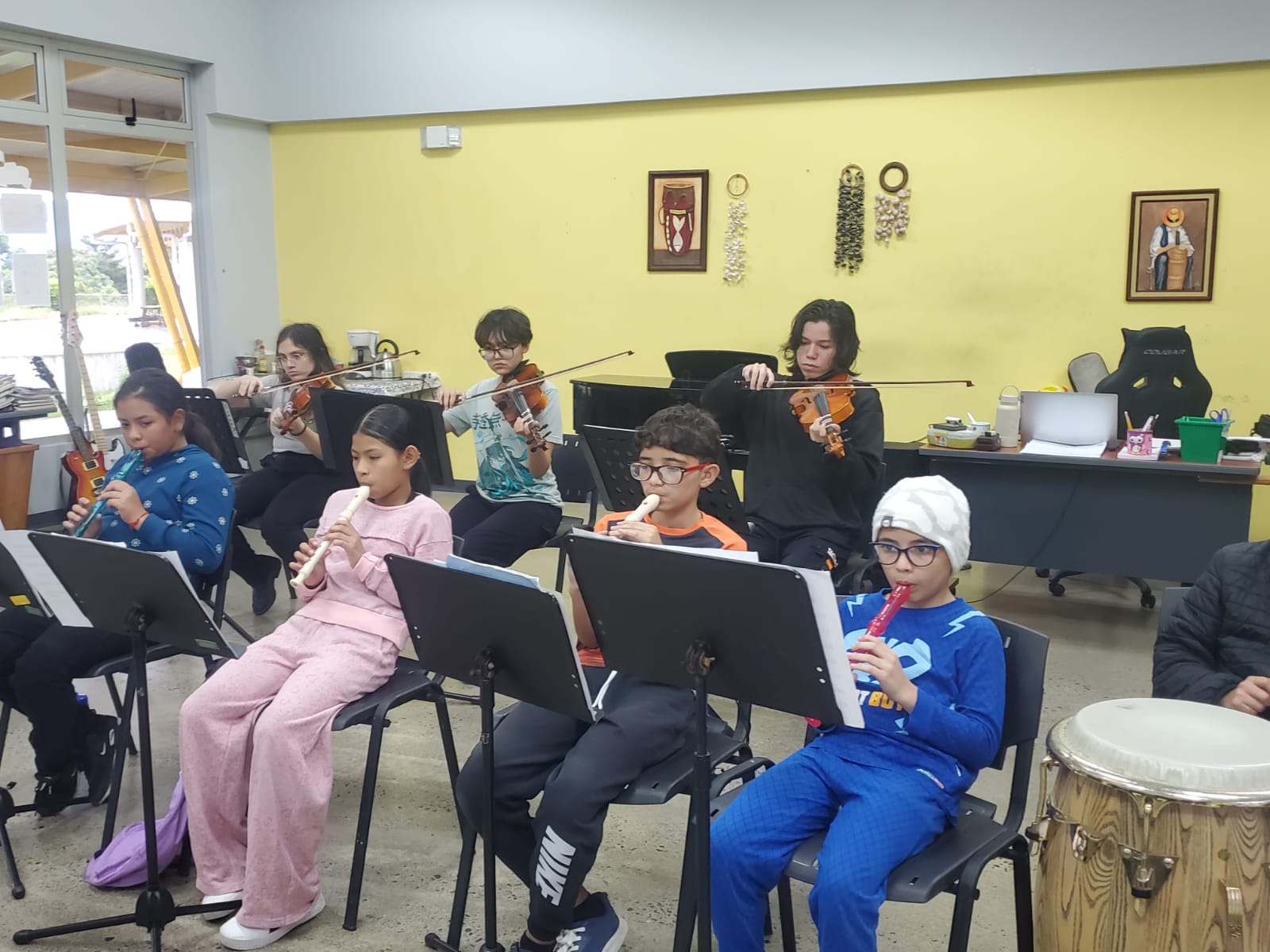 Niños practicando con instrumentos musicales