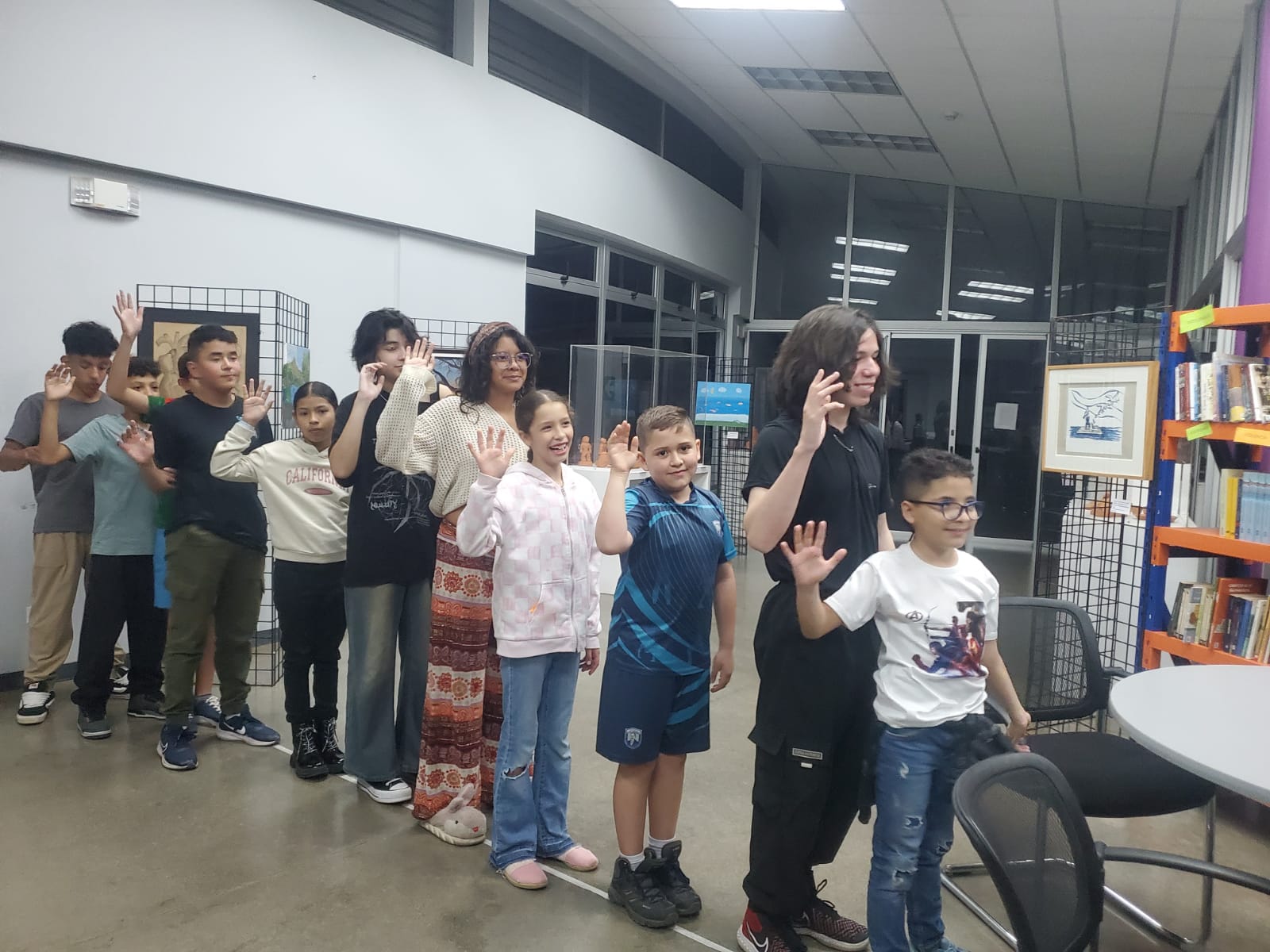 Jóvenes en fila levantando su mano derecha