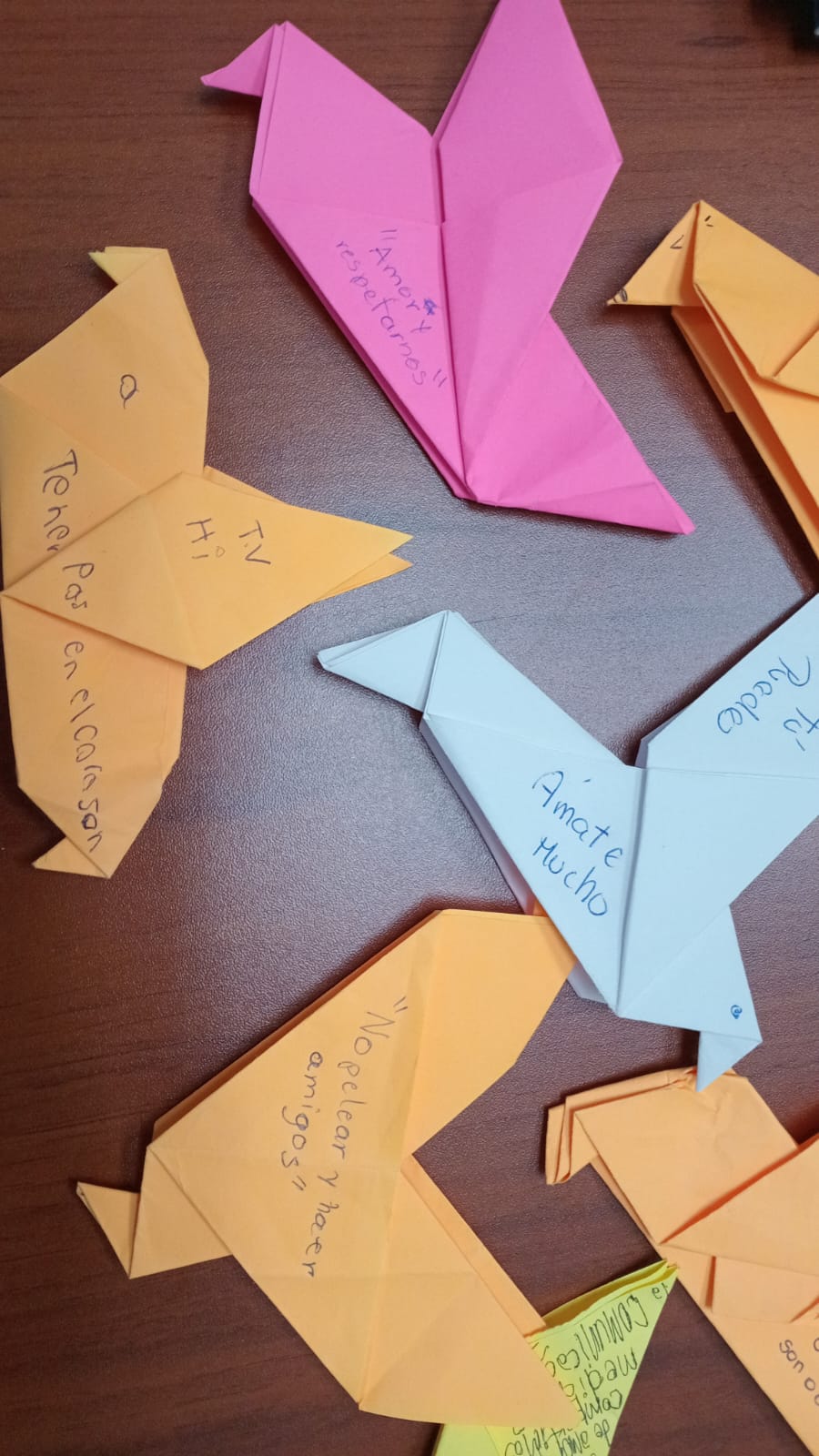 Palomas de papel con mensajes escritos: "No pelear y hacer amigos", "Amate mucho"