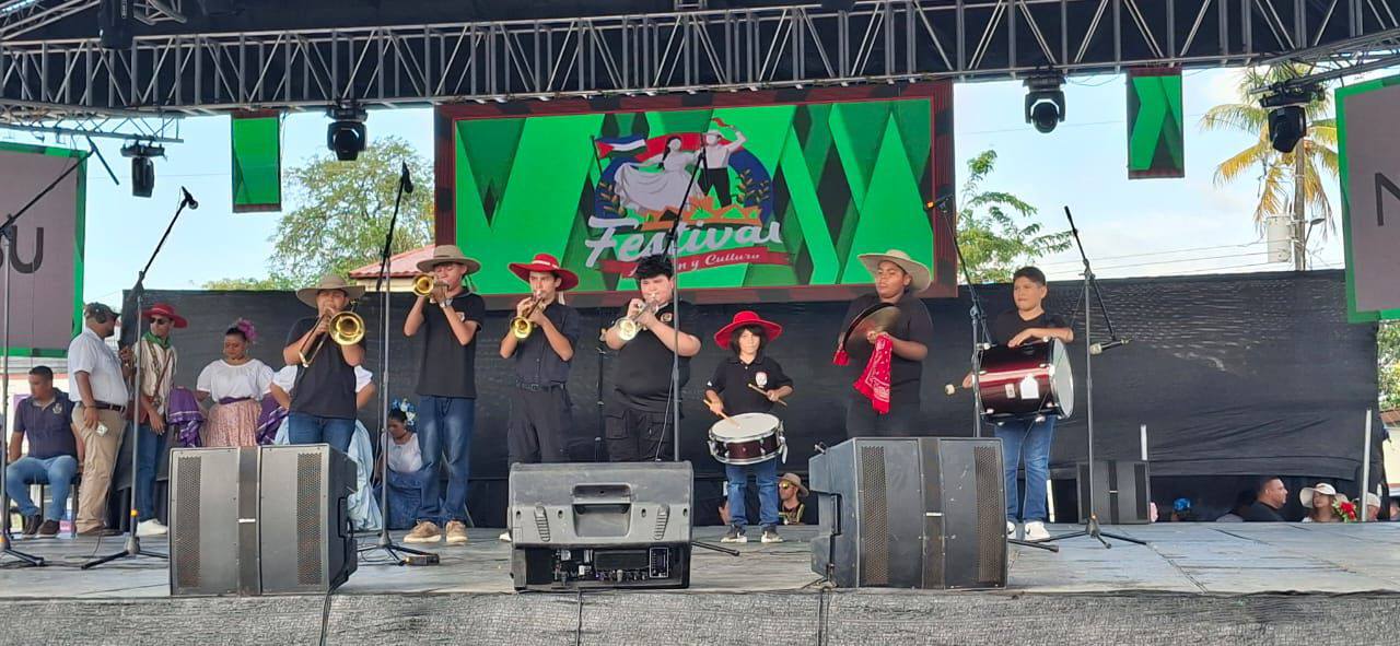 Jóvenes con sombreros tocando instrumentos musicales en una tarima