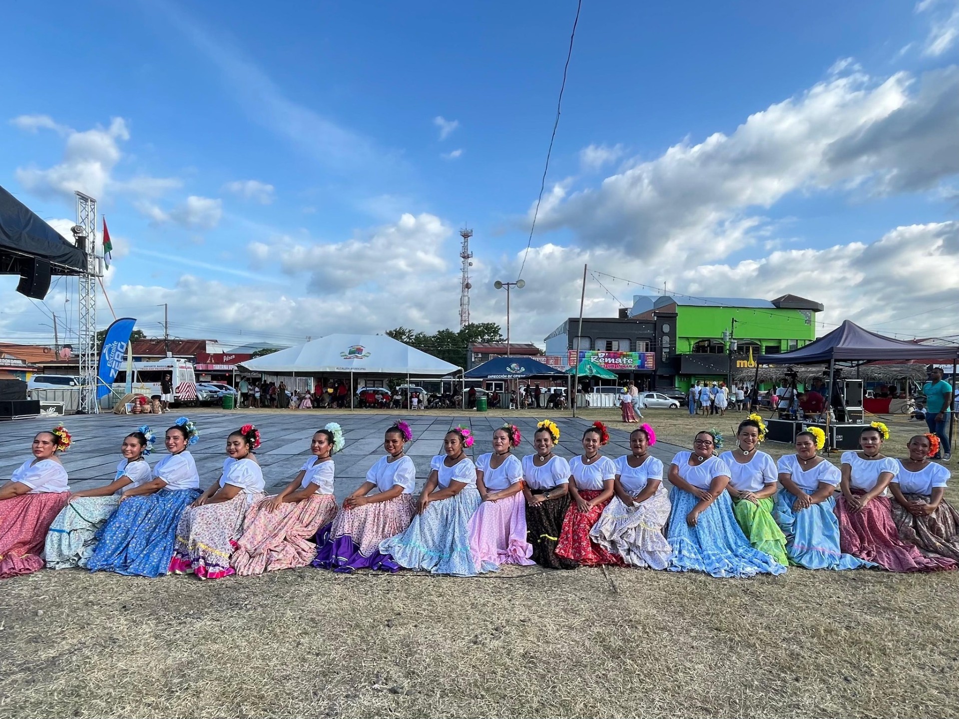 Mujeres sentadas en una tarima con trajes tipicos del folclor costarricense