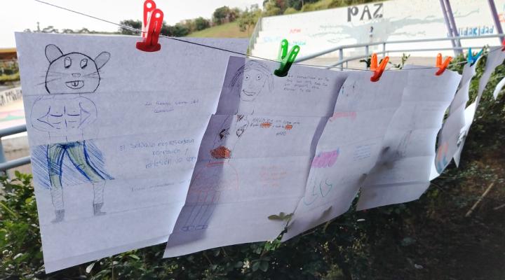 Hojas con dibujos colgadas en una cuerda