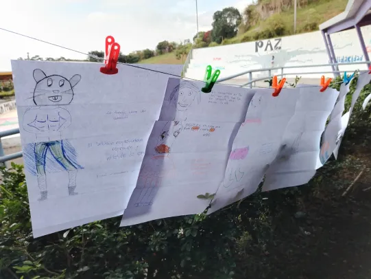 Hojas con dibujos colgadas en una cuerda