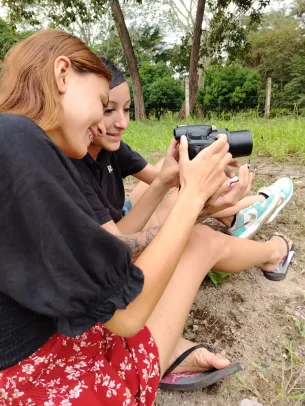 Dos mujeres en el suelo viendo una cámara fotográfica