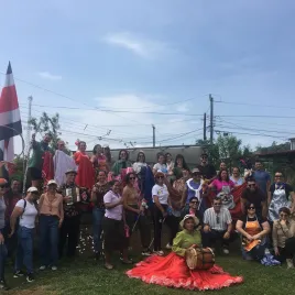 Fotografía de un grupo de personas en una plaza con una bandera de Costa Rica