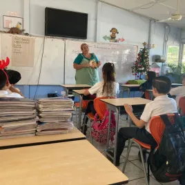 Teresita hablando a un grupo de niños estudiantes