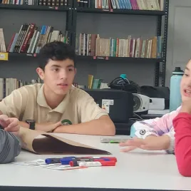 Jovenes sentados en una mesa conversando