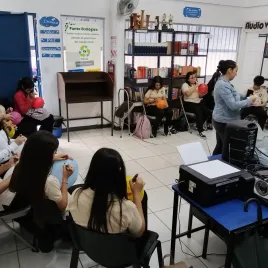 Jovenes con globos sentados en ua aula