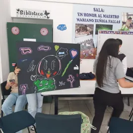 Joven mostrando cartulina negra con dibujo