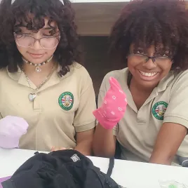 Dos mujeres jovenes mostrando una media mientras sonríen