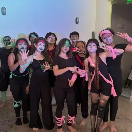 Grupo de jóvenes con la cara pintada saludando