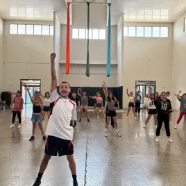 Grupo de personas en un salón bailando y alzando su puño derecho