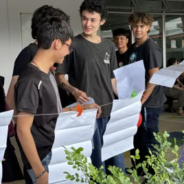 Hombres jóvenes colgando unos papeles en una cuerda