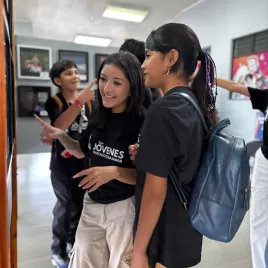 Dos mujeres jóvenes mirando una fotografía colgada en la pared