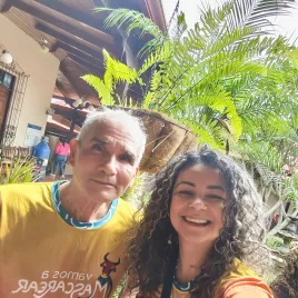 Dos personas viendo a la camara y atrás jardín